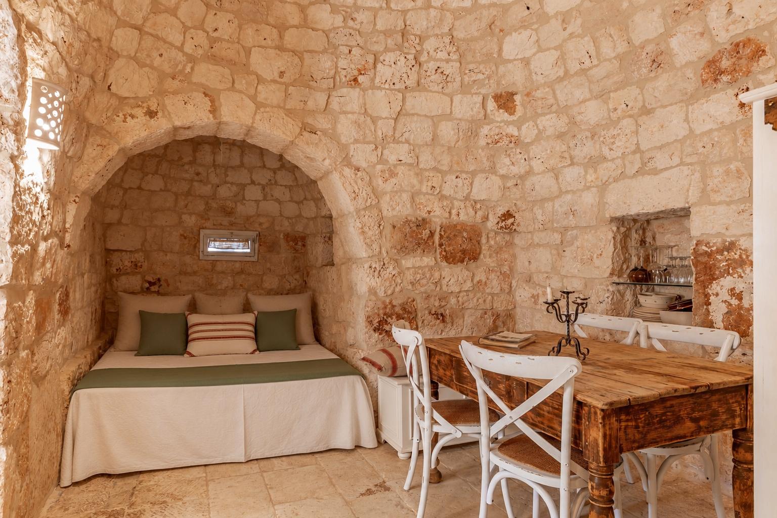 Serene limestone bedroom beneath a trullo cone